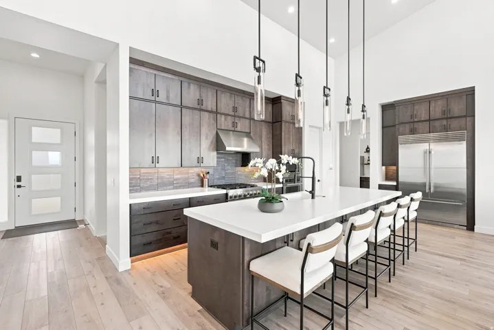 Kitchen with light wood-finish flooring, dark wood cabinetry, white countertops, and a full suite of stainless steel appliances