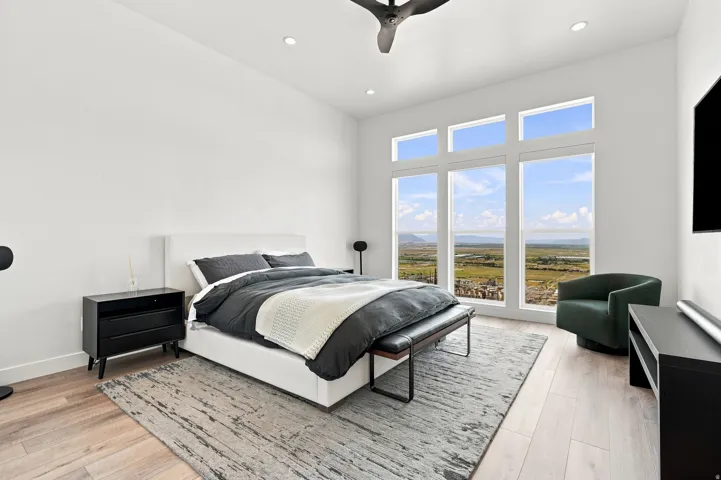 Expansive windows with scenery, high ceilings, recessed lighting, and wood-finish flooring