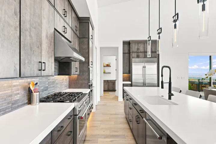 Expansive kitchen island with an undermount sink, matte black faucet, and pendant lighting