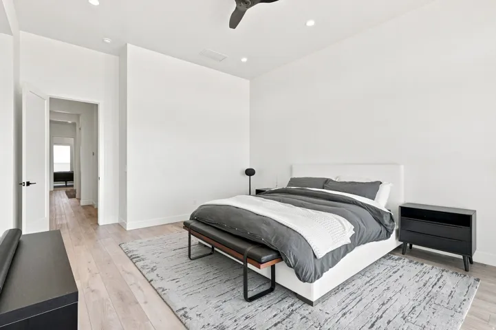 High ceilings, wood-finish flooring, recessed lighting, and a modern ceiling fan