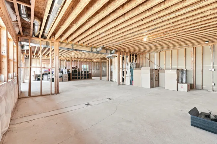 Unfinished basement with exposed wood framing, concrete flooring, and visible ductwork