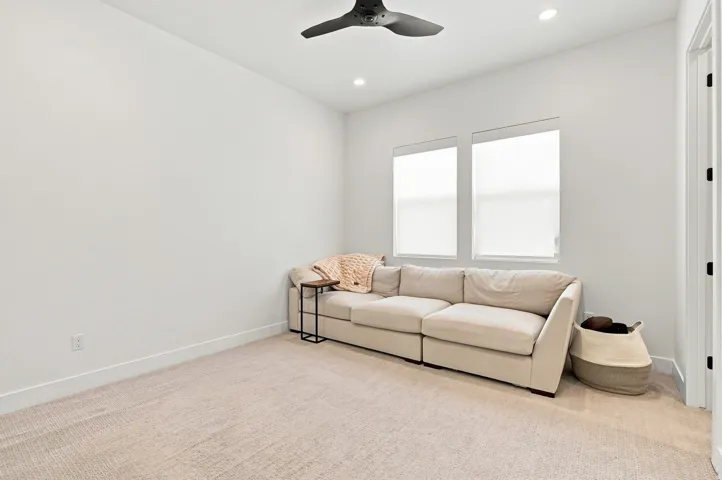 Recessed lighting, ceiling fan, carpeting, dual windows with roller shades, and a white interior door