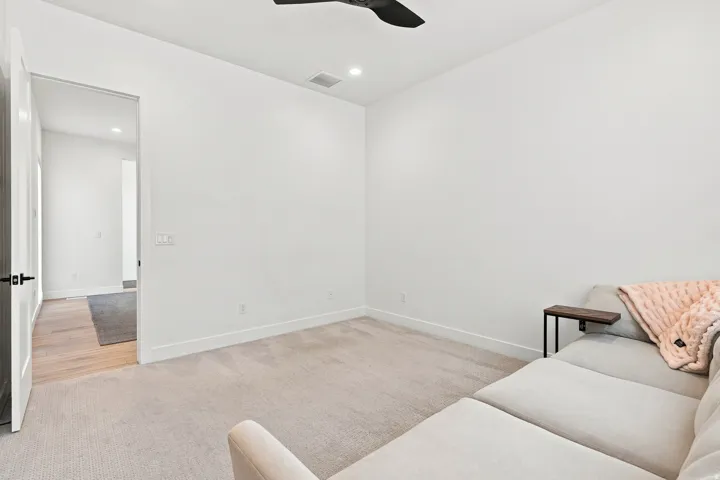 Recessed lighting, ceiling fan, carpeting, and light wood-finish flooring in the doorway