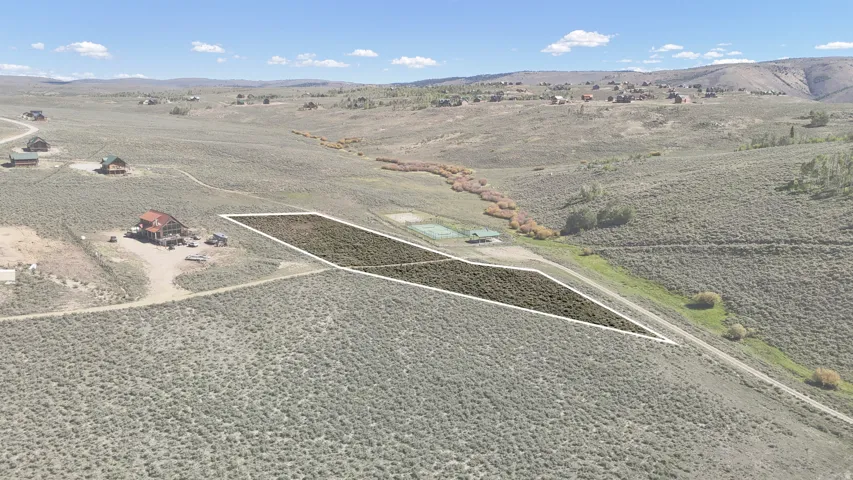 Expansive land parcel featuring natural terrain and distant mountainous backdrop