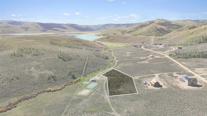 Expansive lot featuring natural terrain, surrounding hills, and a distant body of water