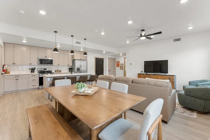 Open-concept living space with wood-finish flooring, a contemporary kitchen, stainless steel appliances, and recessed lighting
