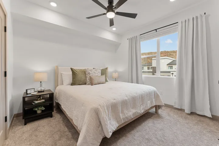 Recessed lighting, ceiling fan, white window treatments, and carpet flooring