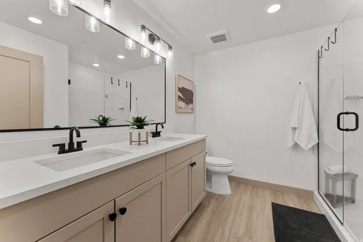 Dual vanity with integrated sinks, white countertops, and matte black fixtures