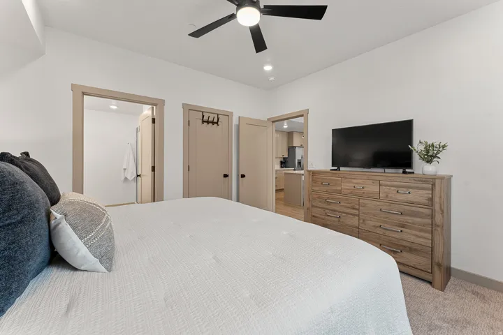 Recessed lighting, ceiling fan with black blades, and light-colored wall-to-wall carpeting