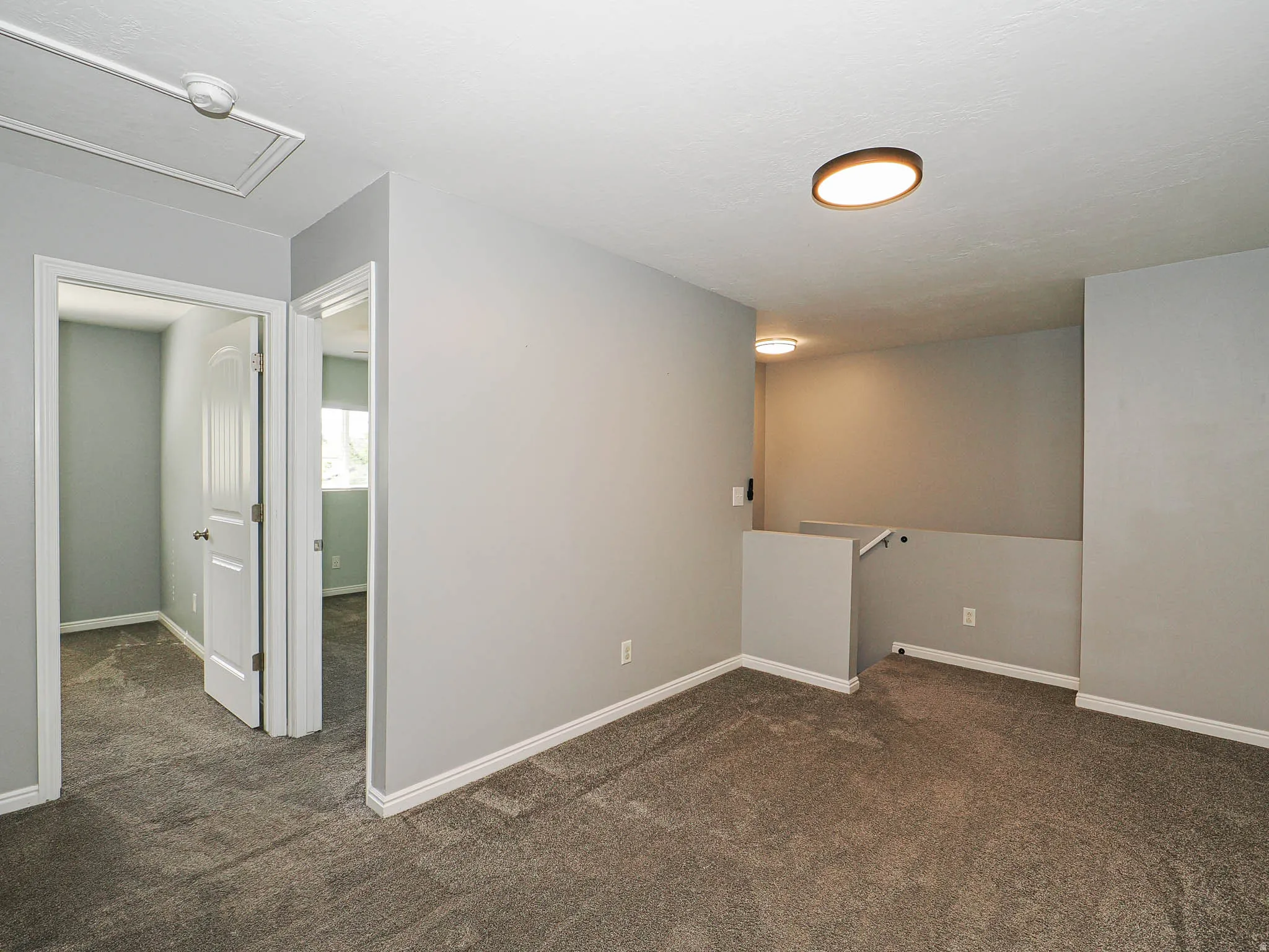 Carpeted floor, neutral wall paint, flush mount lighting, white baseboards, and white interior doors