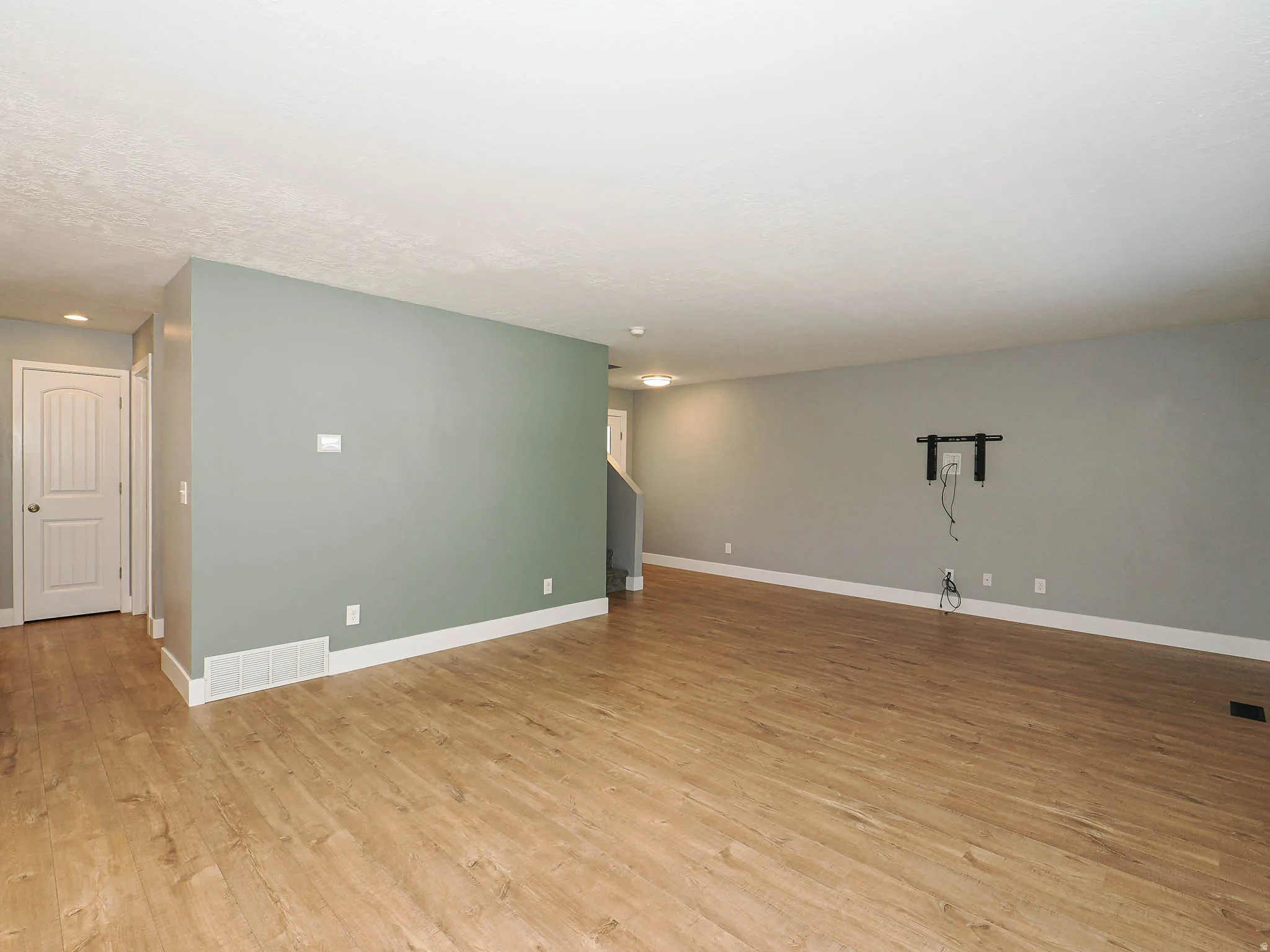 Expansive interior with wood-finish flooring, light-toned walls, and recessed lighting