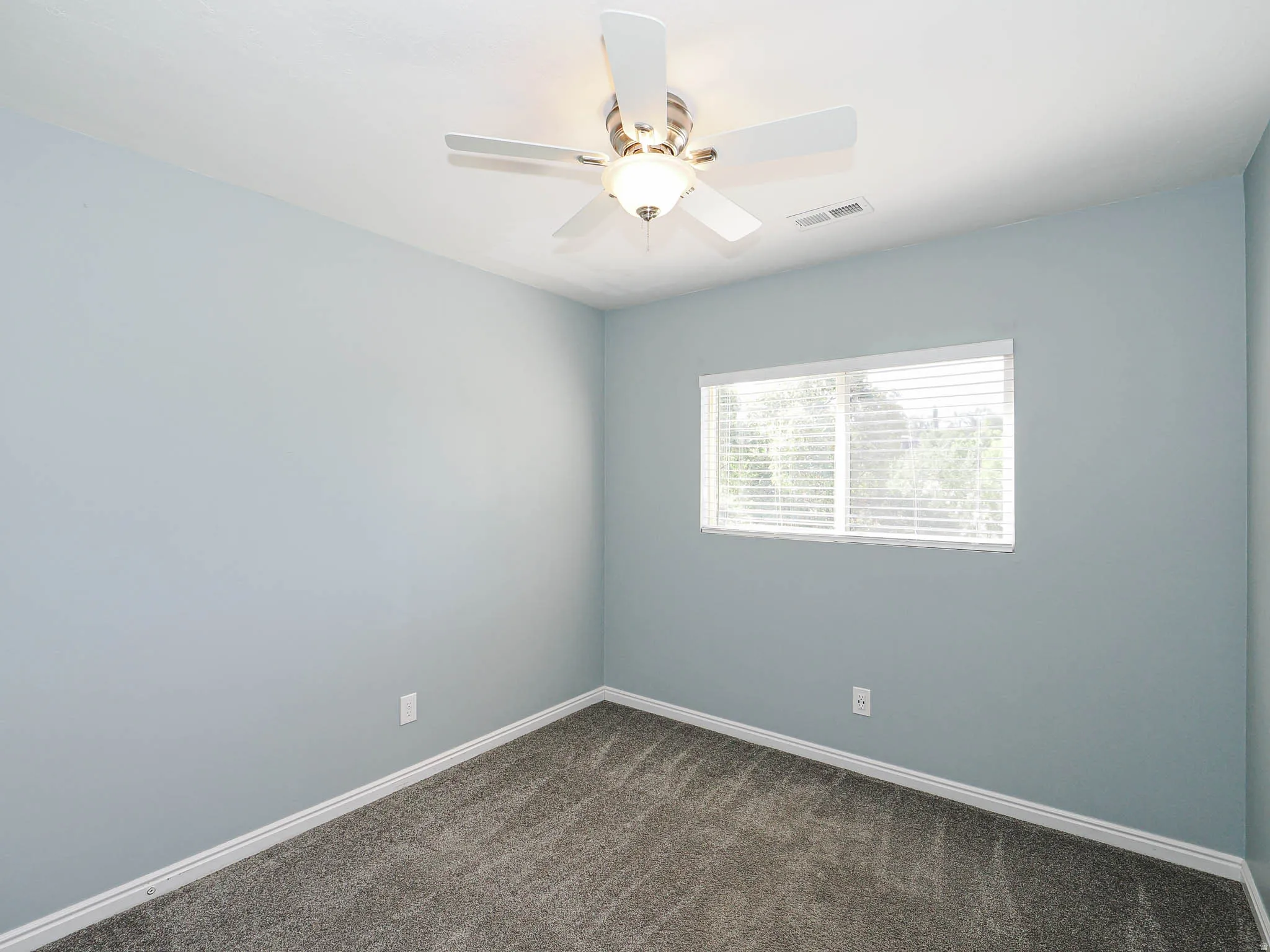 Soft gray-blue walls with neutral carpet flooring and white trim