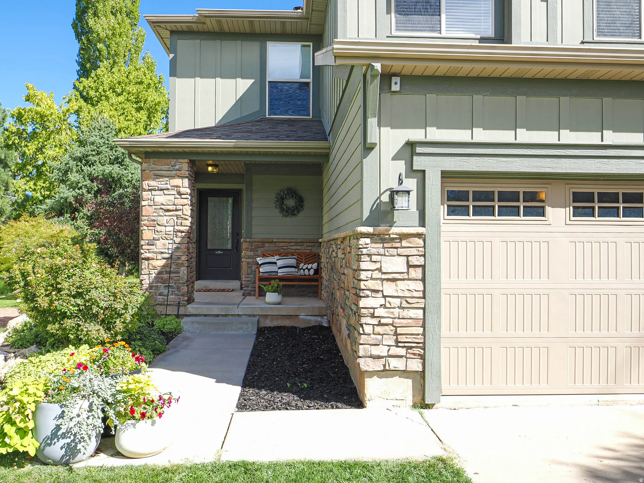 Two-story exterior with vertical siding and stone veneer accents