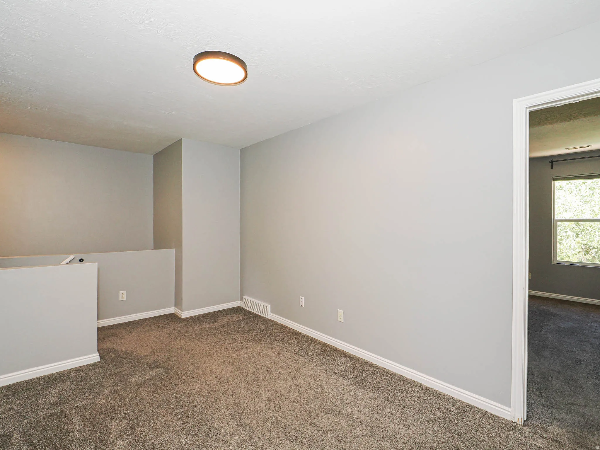 Carpeted interior with light gray painted walls, white trim, and a flush mount ceiling light fixture