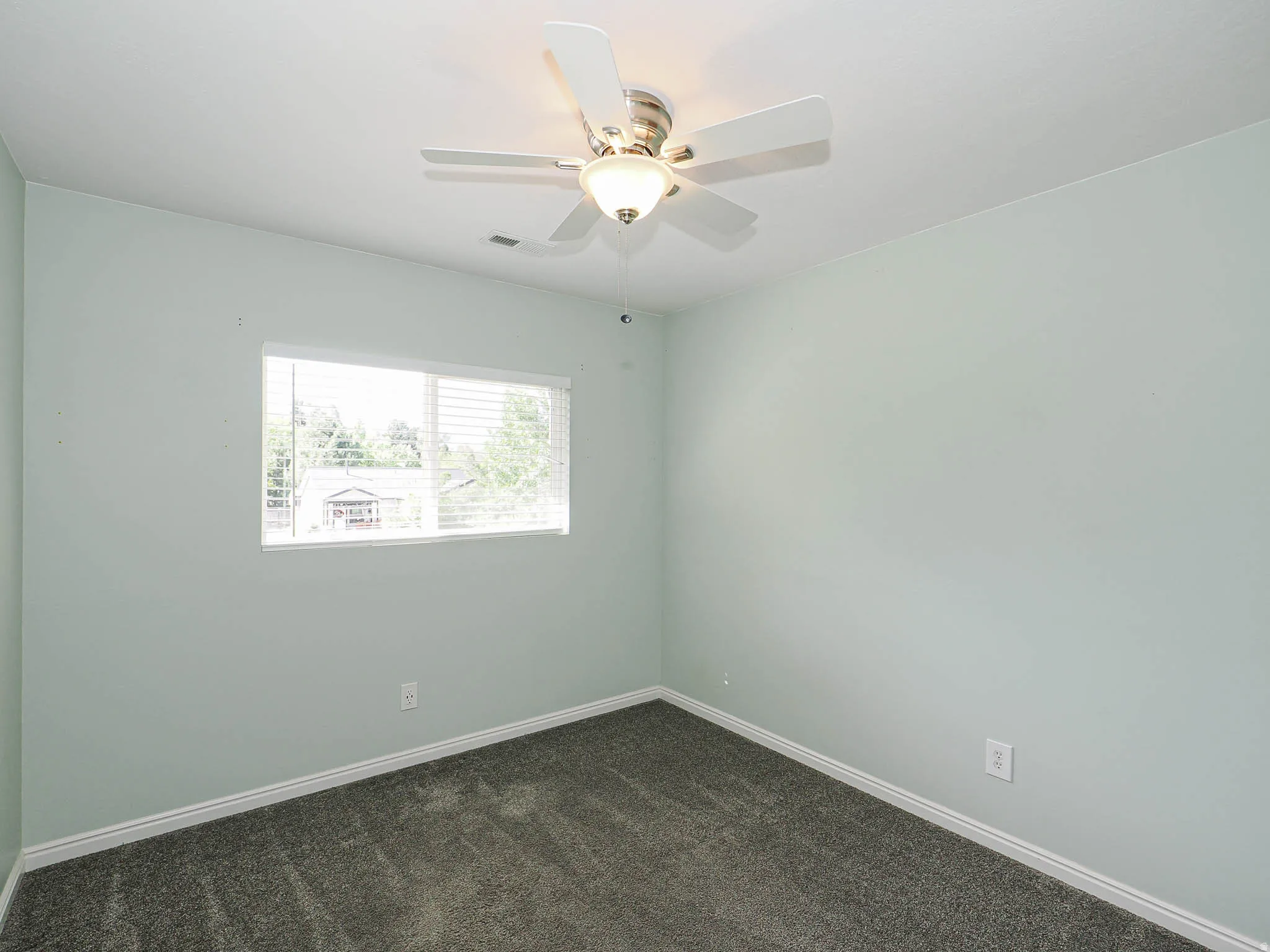 Window with blinds, ceiling fan with integrated lighting, and carpeted flooring