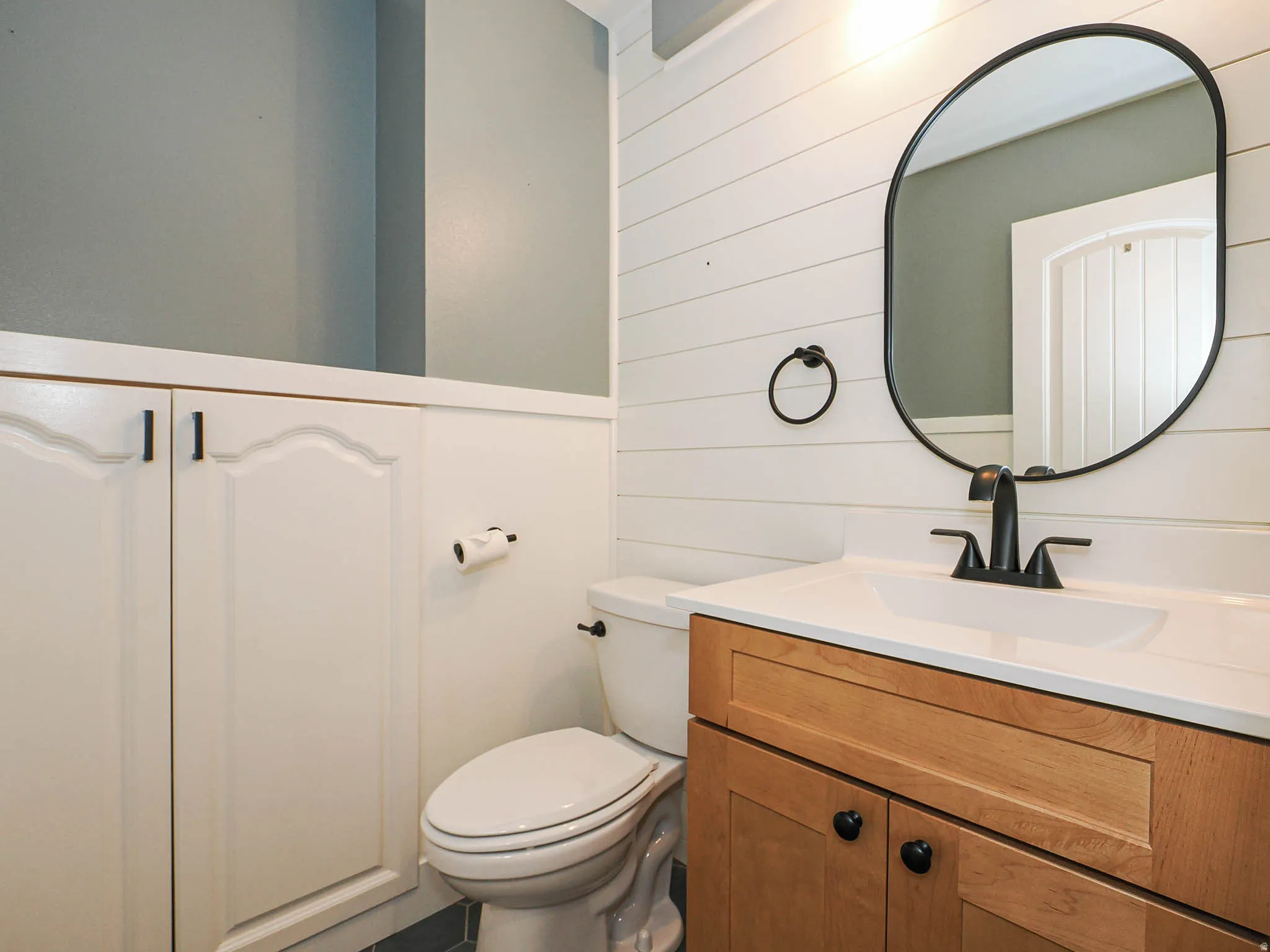 Wood-finish vanity with a white countertop and rectangular undermount sink