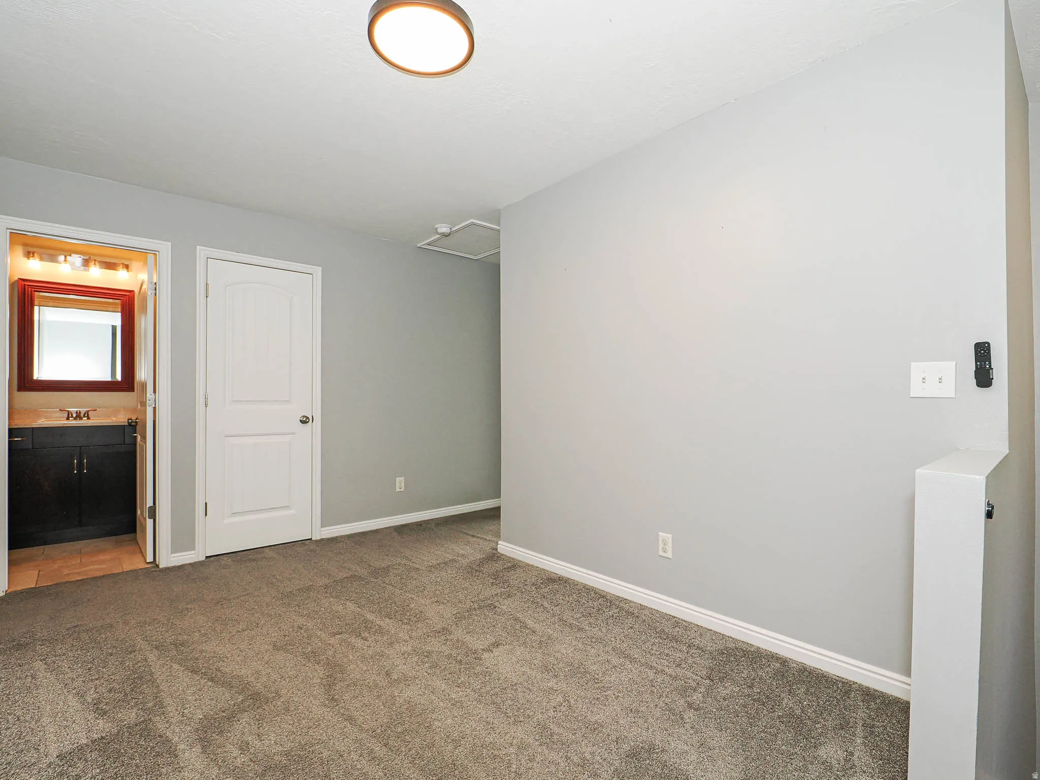 Gray carpeting, white trim, and a white interior door with an arched panel design