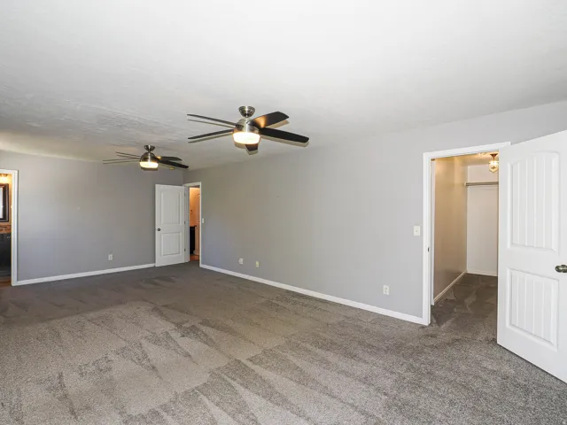 Spacious room with gray carpeting and light gray wall paint