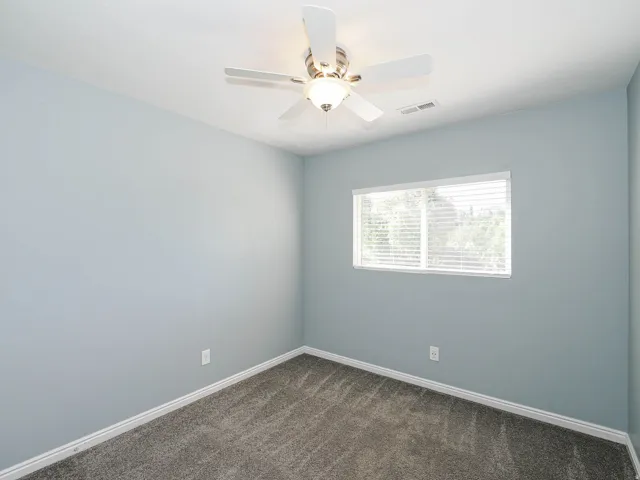 Soft gray-blue walls with neutral carpet flooring and white trim