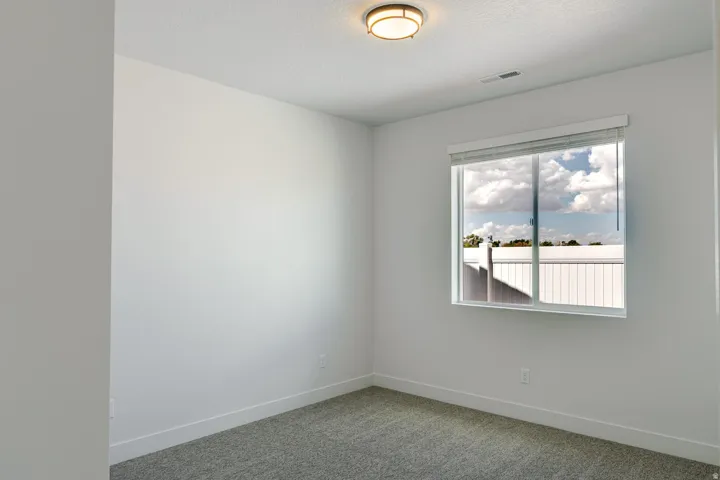 Neutral wall color, wall-to-wall carpeting, recessed ceiling light, window with blinds