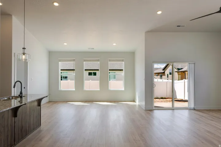 Open-concept living space with wood-finish flooring, recessed lighting, and a vaulted ceiling