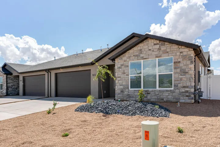 Stone veneer accents complemented by stucco siding and dark roof shingles