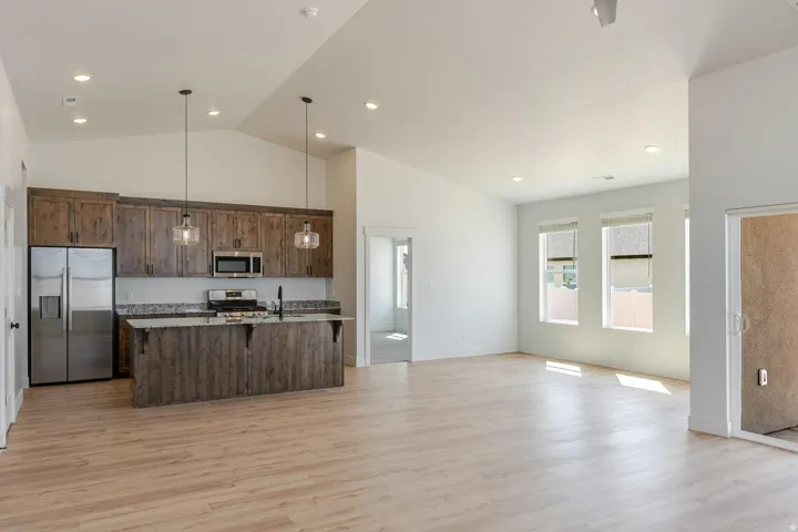 Vaulted ceiling, recessed lighting, wood-finish flooring, wood-finish cabinetry, stainless steel appliances