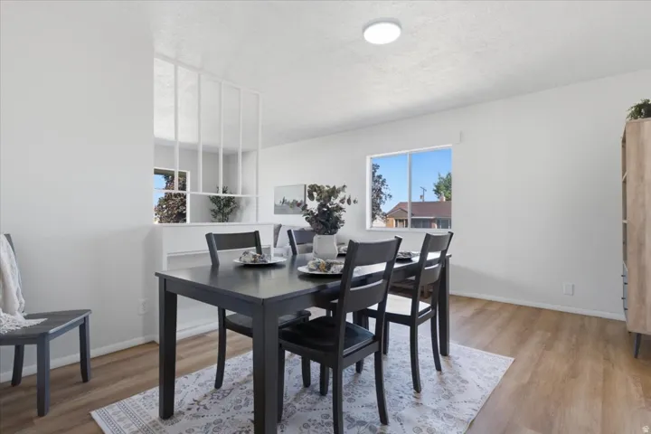Open dining area featuring wood-finish flooring, a flush-mount ceiling light, and a window with exterior visibility