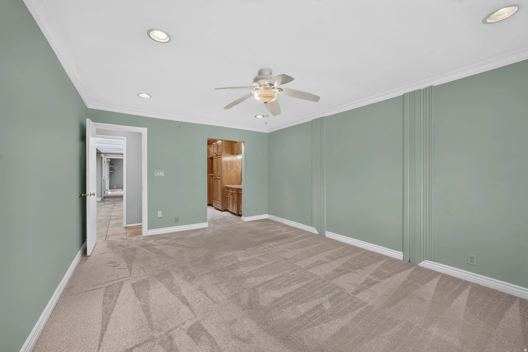 Recessed lighting, crown molding, ceiling fan, and carpeted flooring