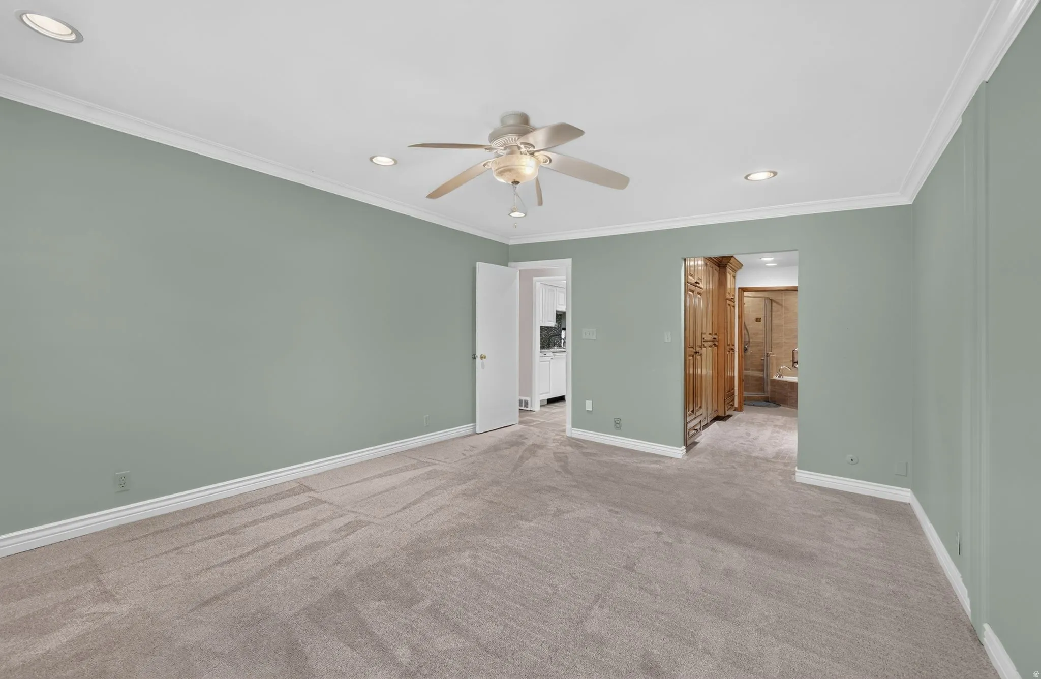 Recessed lighting, crown molding, ceiling fan, and carpeted flooring