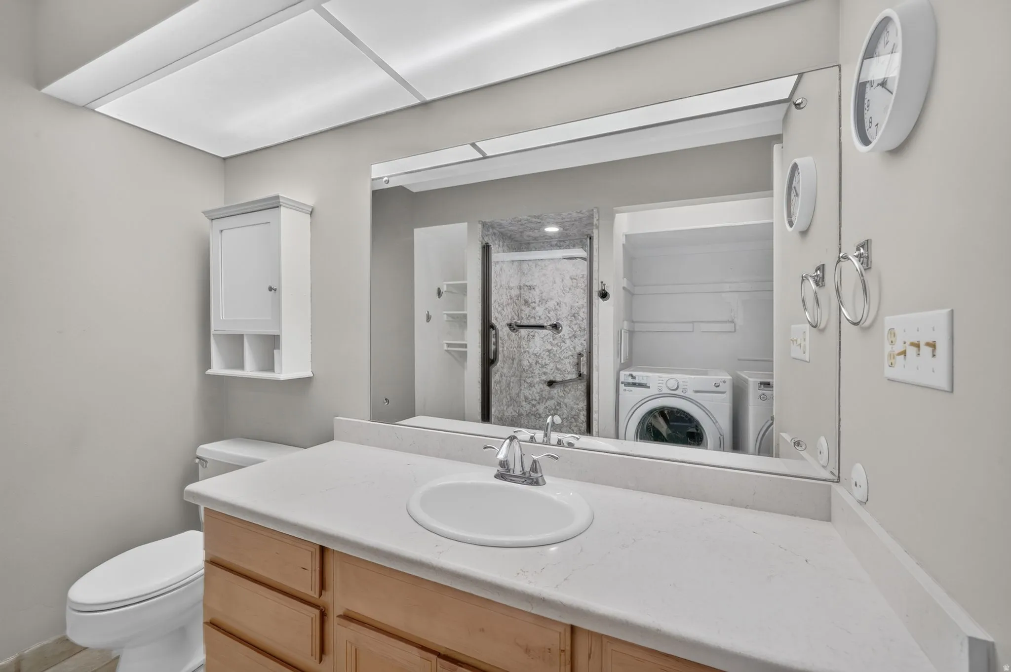 Vanity with a built-in sink, wood-finish cabinetry, and light-toned countertop