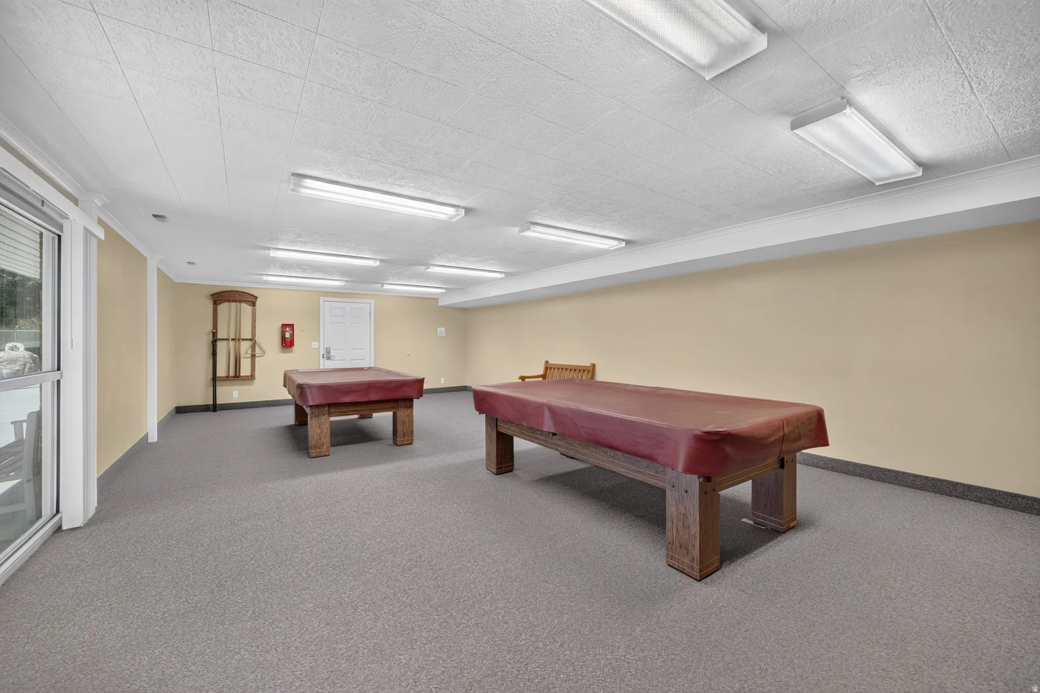 Spacious recreational room with neutral wall tones and a textured ceiling
