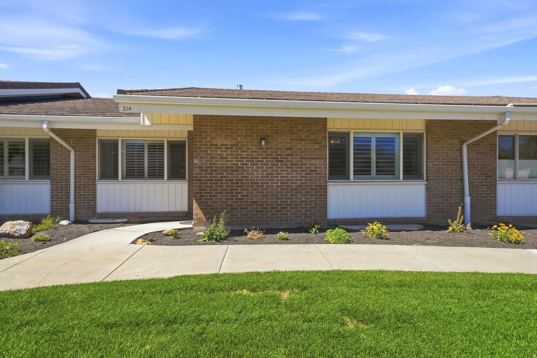 Brick exterior with a brown shingle roof