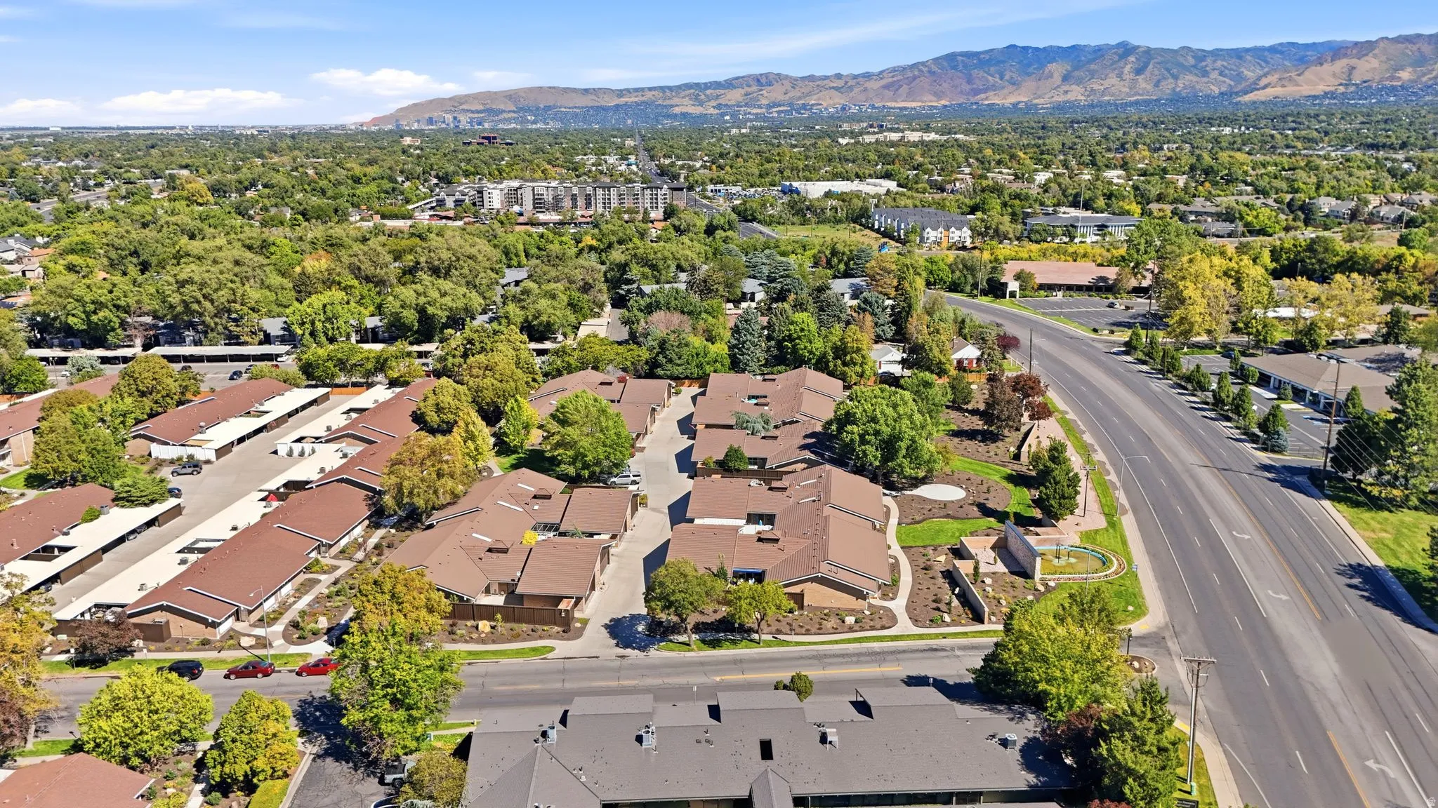 Community featuring multiple residential buildings, paved roadways, and covered parking structures