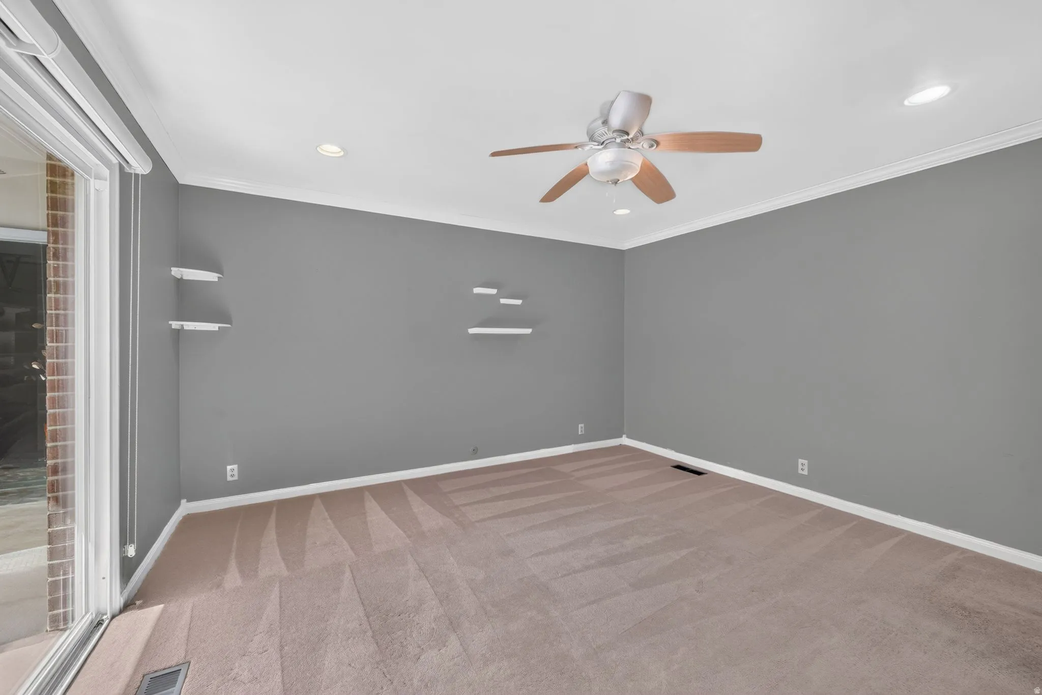 Recessed lighting with a ceiling fan, crown molding, and a sliding glass door