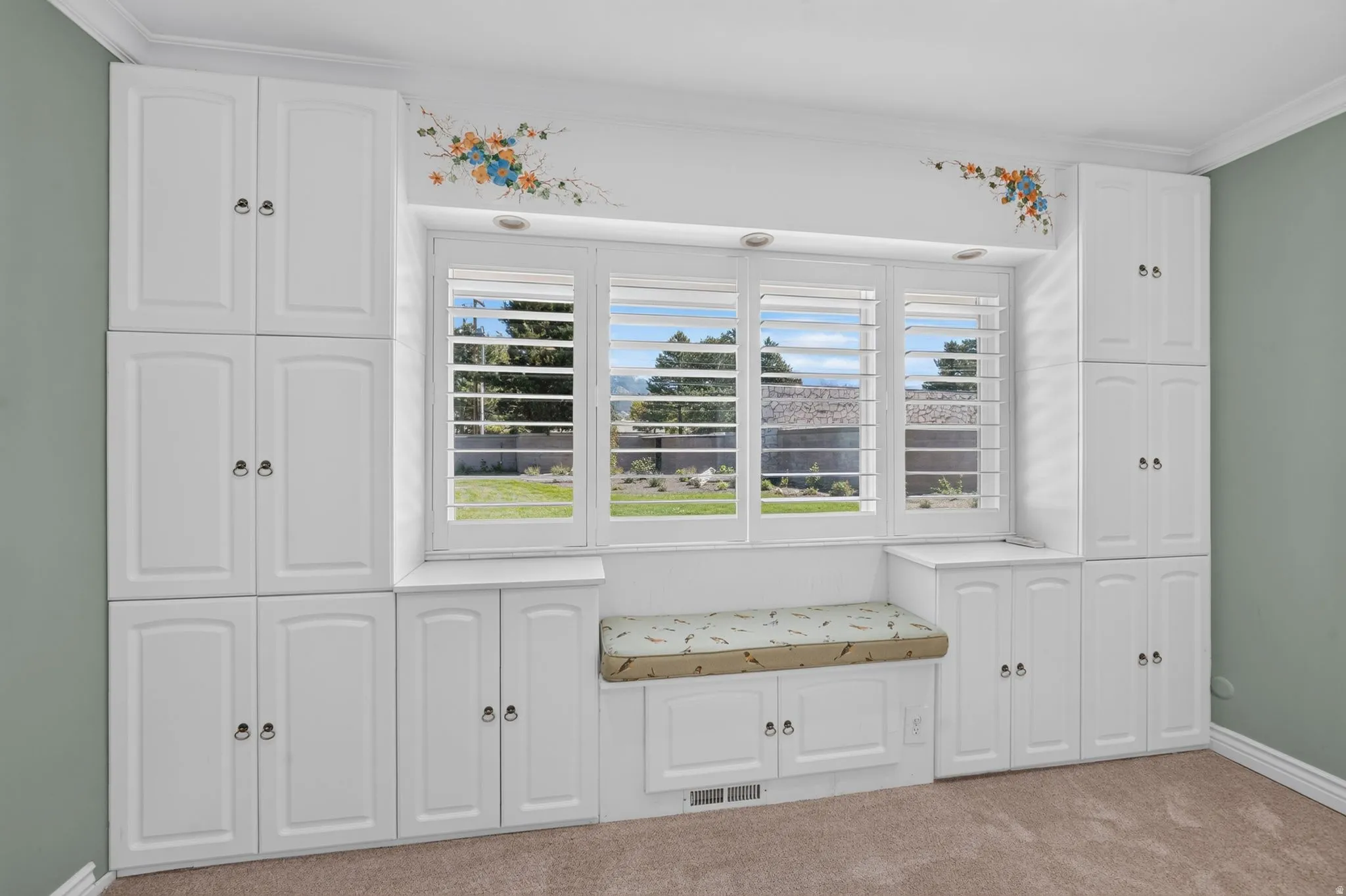 Built-in white cabinetry and a window seat with storage