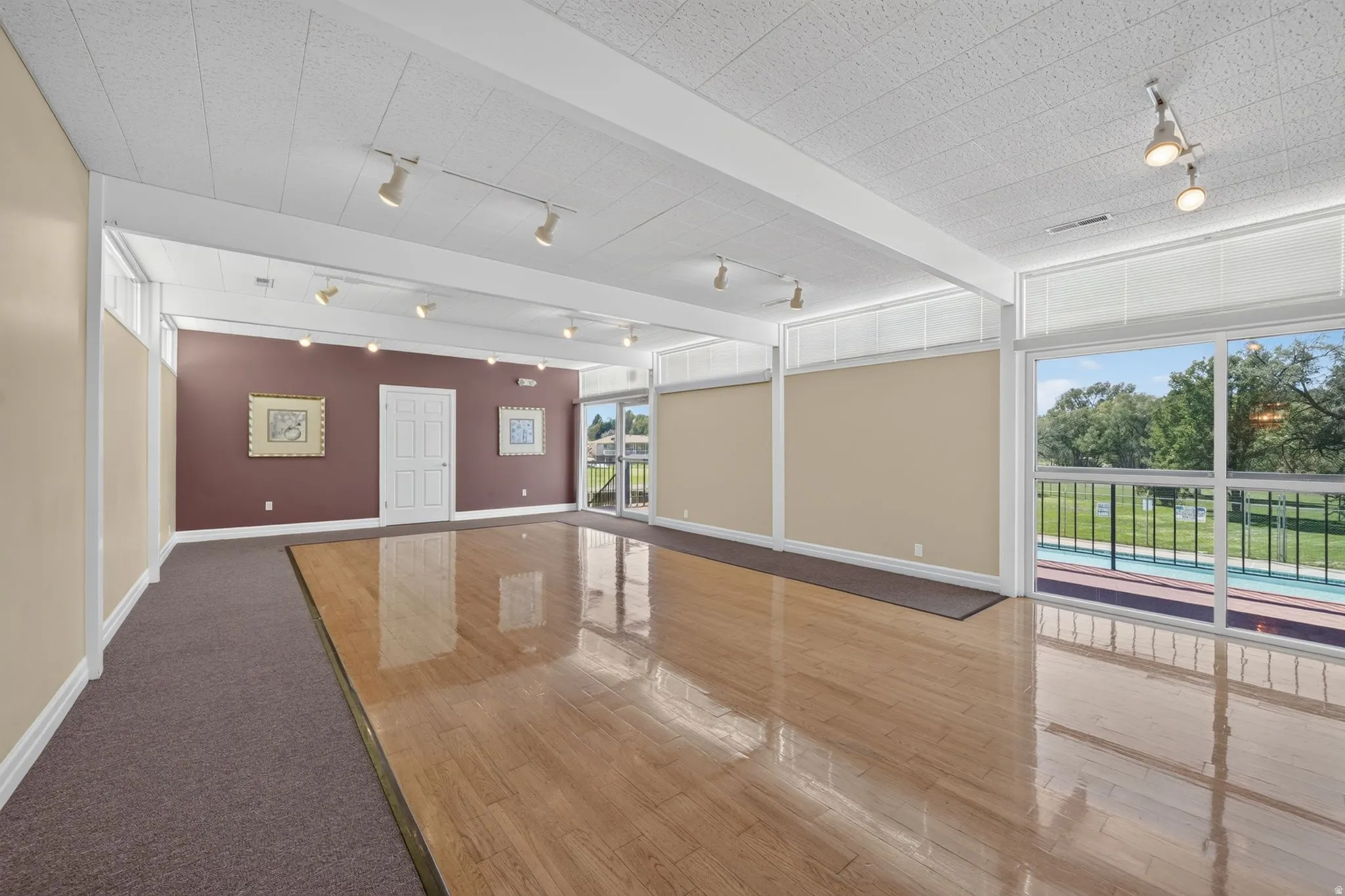 Expansive interior space featuring wood-finish flooring, track lighting, and substantial windows