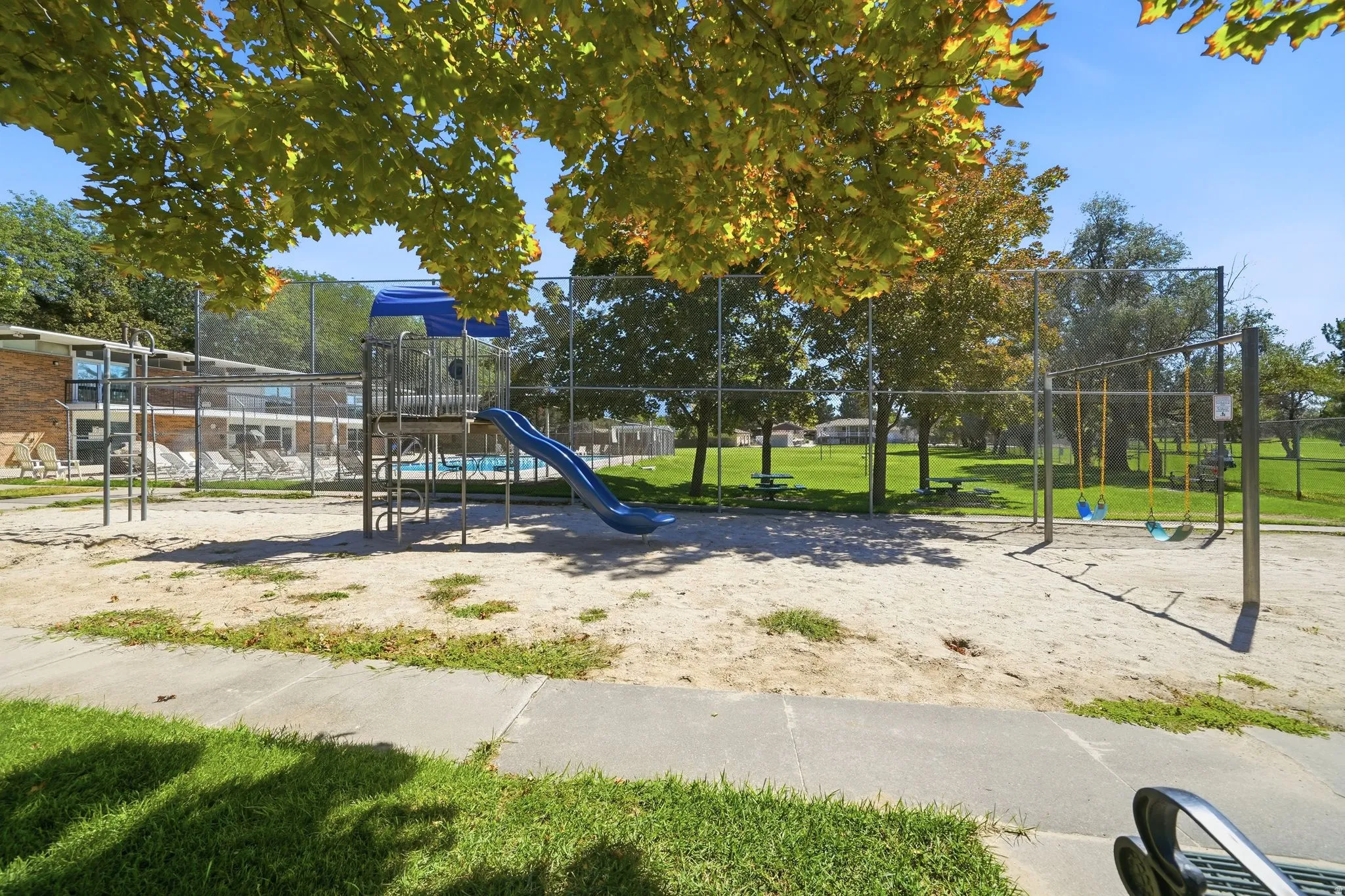 Sand play area featuring a slide and swing set