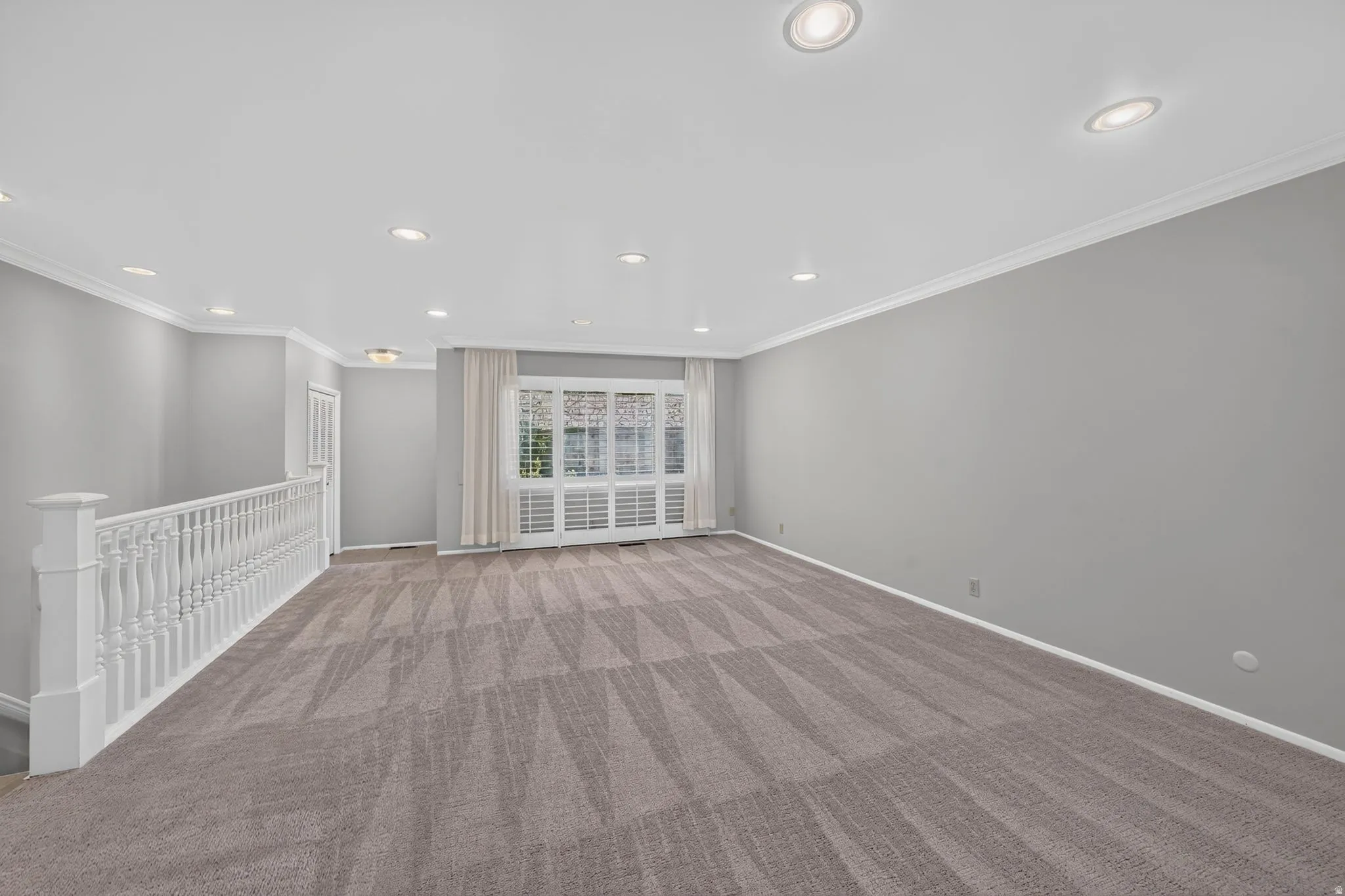 Spacious room with carpet flooring, recessed lighting, and crown molding