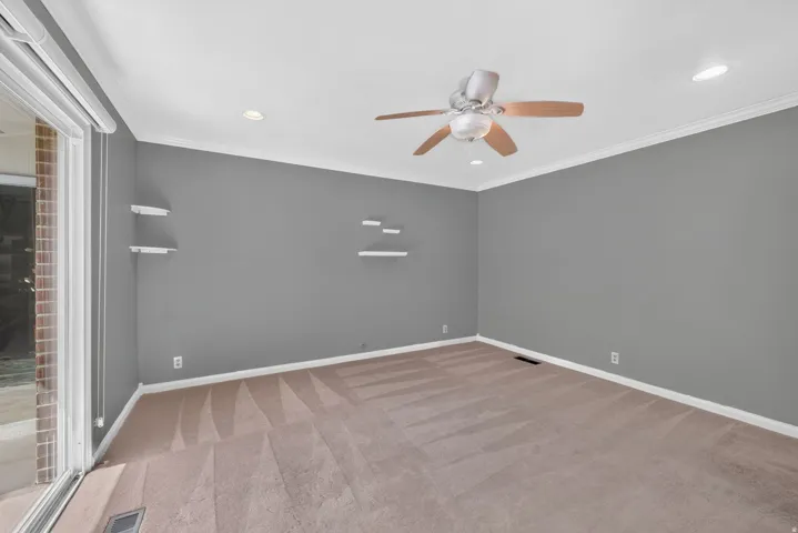 Recessed lighting with a ceiling fan, crown molding, and a sliding glass door
