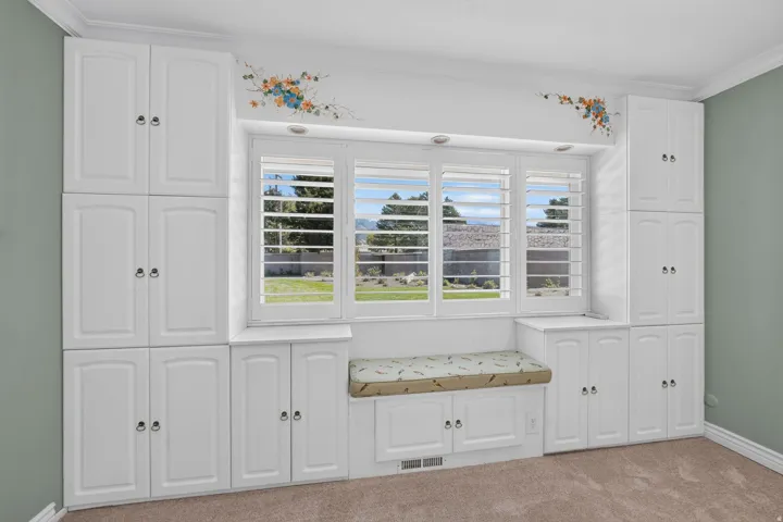 Built-in white cabinetry and a window seat with storage