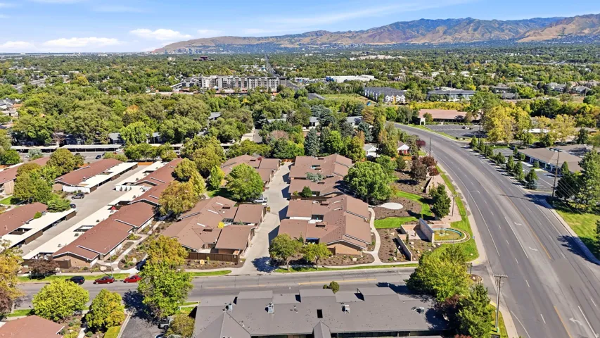 Community featuring multiple residential buildings, paved roadways, and covered parking structures
