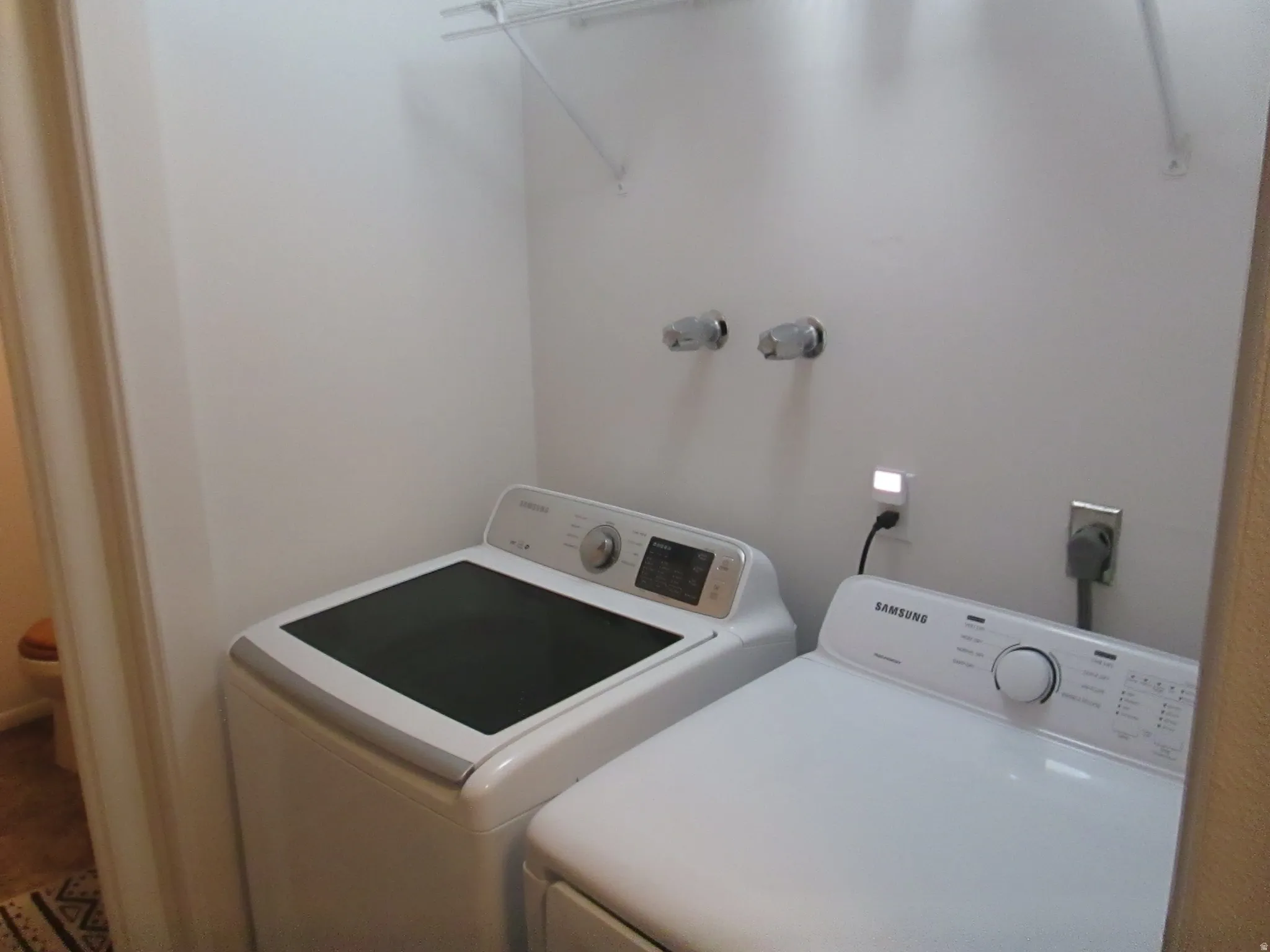 Laundry area featuring a wire shelf and wall-mounted hookups