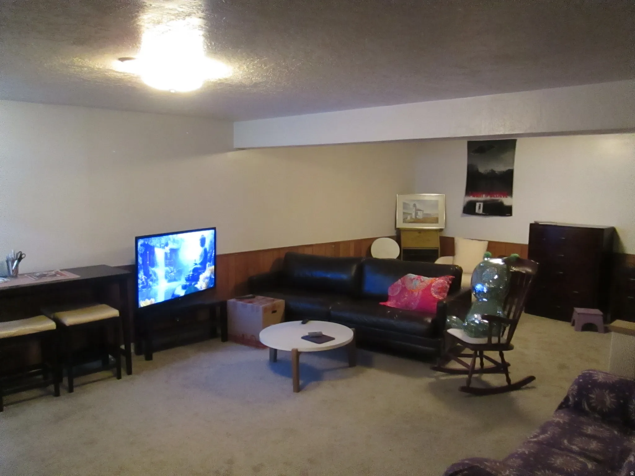 Carpeted room with recessed wall paneling and overhead lighting