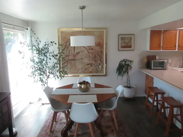 Recessed lighting, wood-finish flooring, and white walls create a neutral palette for personalized decor