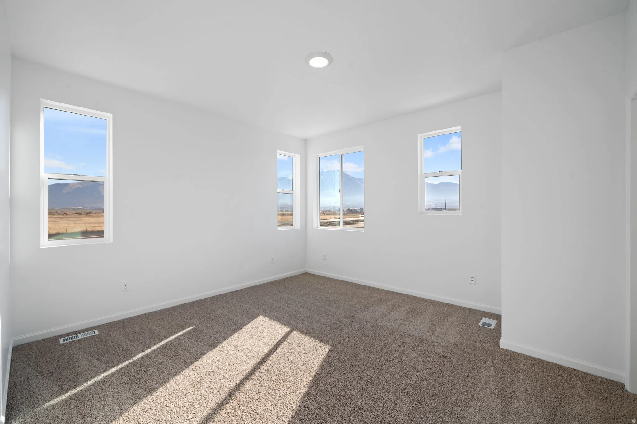 Neutral wall finishes, recessed ceiling lighting, and multiple windows