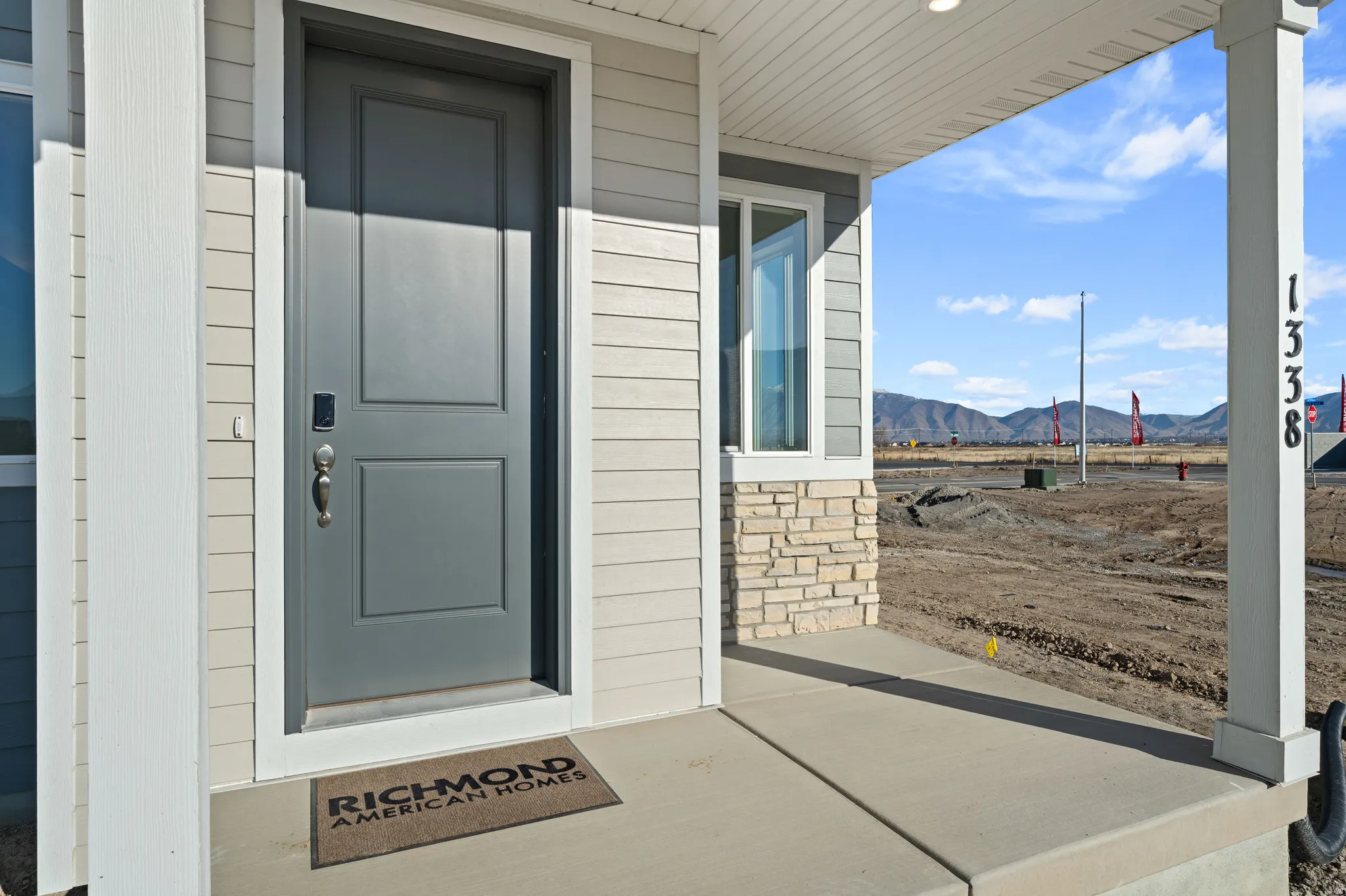 Entry with a gray paneled door and metal hardware