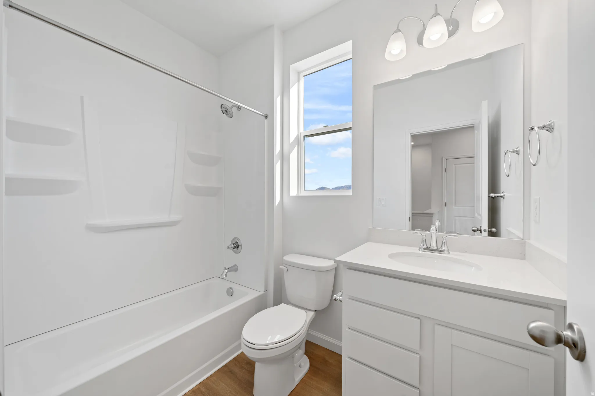 White vanity with integrated sink, chrome faucet, and storage cabinetry