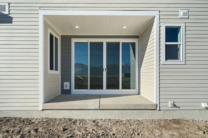 Sliding glass doors with direct patio access, recessed lighting, and durable siding exterior