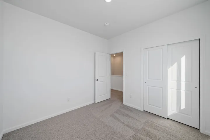 Neutral carpeted flooring with white painted walls